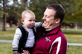 Photo of a man holding a baby. Link to Gifts of Cash, Checks, and Credit Cards.