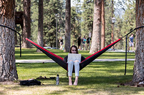 Photo of a student relaxing on campus. Link to Gifts of Real Estate.